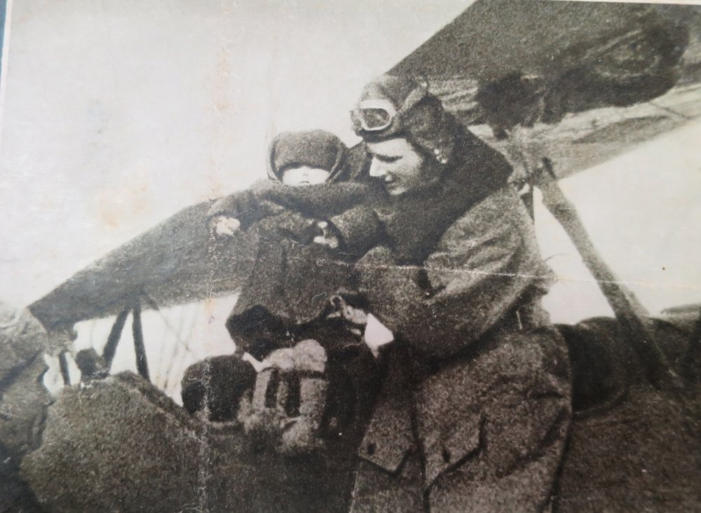 Мамкин Александр Петрович усаживает ребенка в кабину самолета.jpg